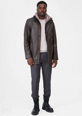 Man wearing a gray leather coat with fur lining, white shirt, gray pants, and black boots on a white background.