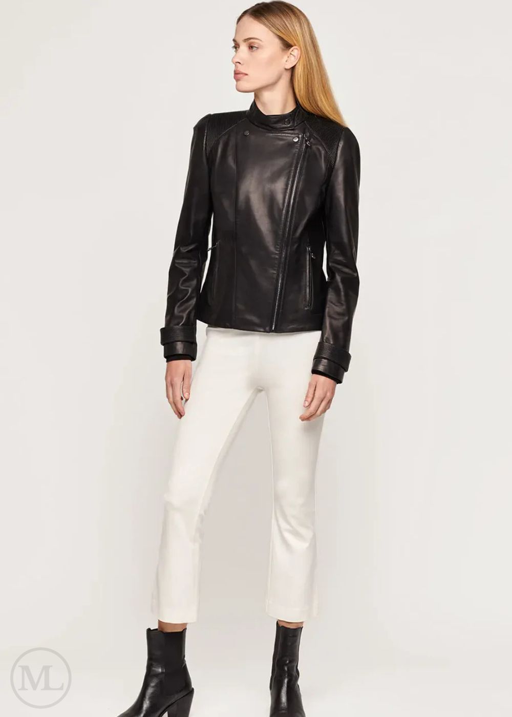Woman wearing a black leather biker jacket and white pants on a white background