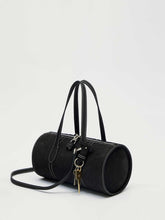 Black handbag with a strap on a light gray background