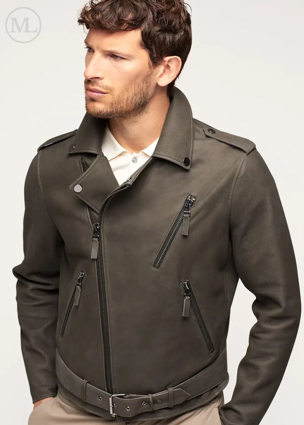 Man wearing a olive khaki leather biker jacket with zippers on a light gray background