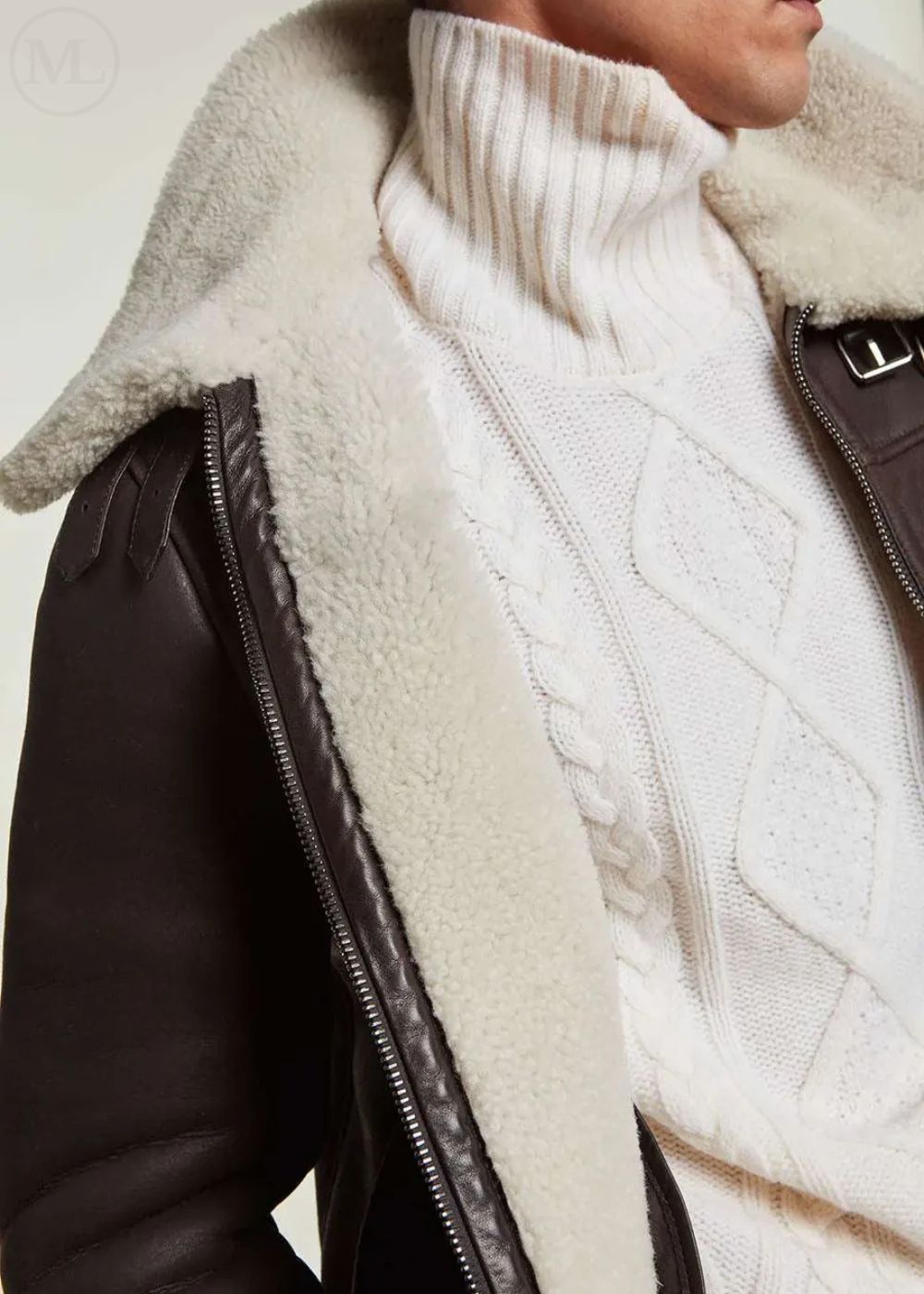 Close-up of a man wearing a aviator leather jacket with a shearling collar and leather sleeves.